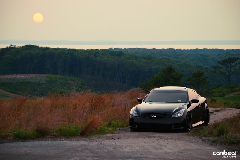Black Infiniti on a dirt road