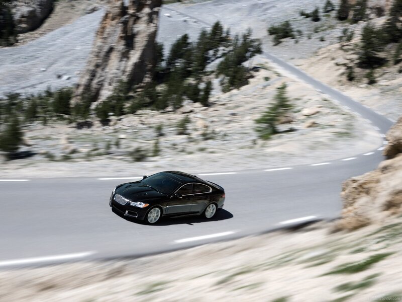 Black Jaguar driving on mountain road