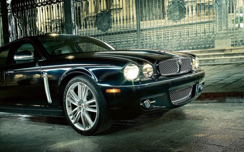 Black Jaguar XJ in front of gate