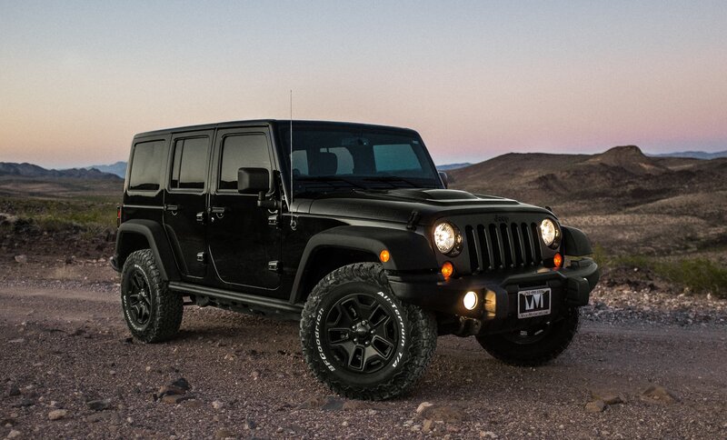 Black Jeep in desert at dusk