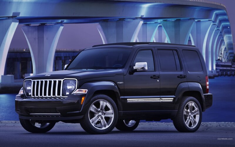 Black Jeep Liberty parked under bridge