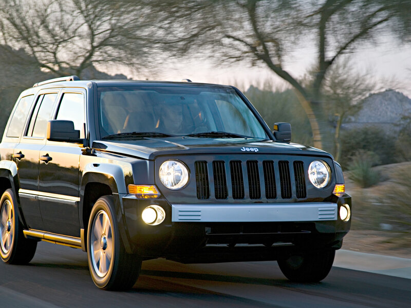Black Jeep Patriot driving on road