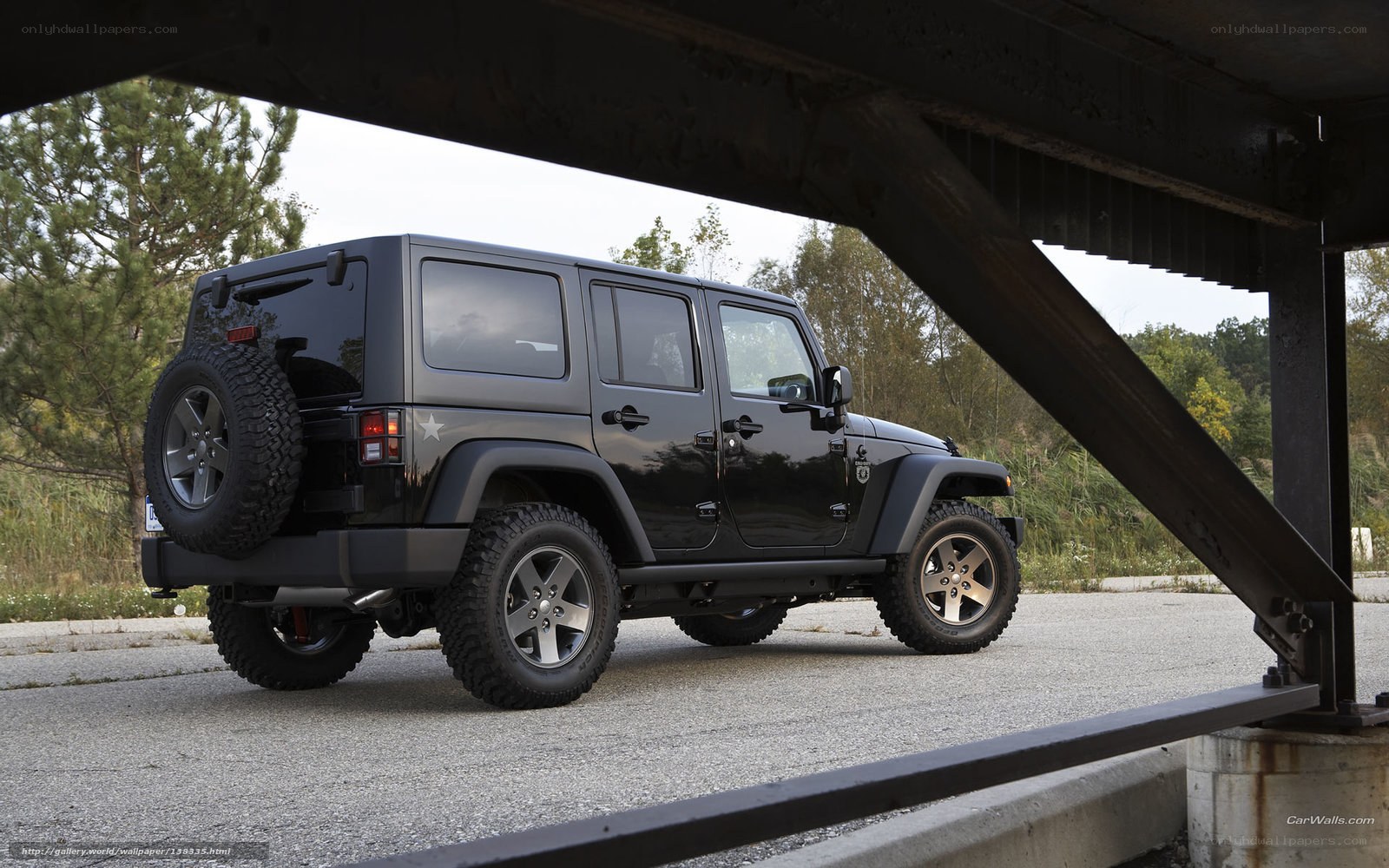 Black Jeep Wrangler under bridge