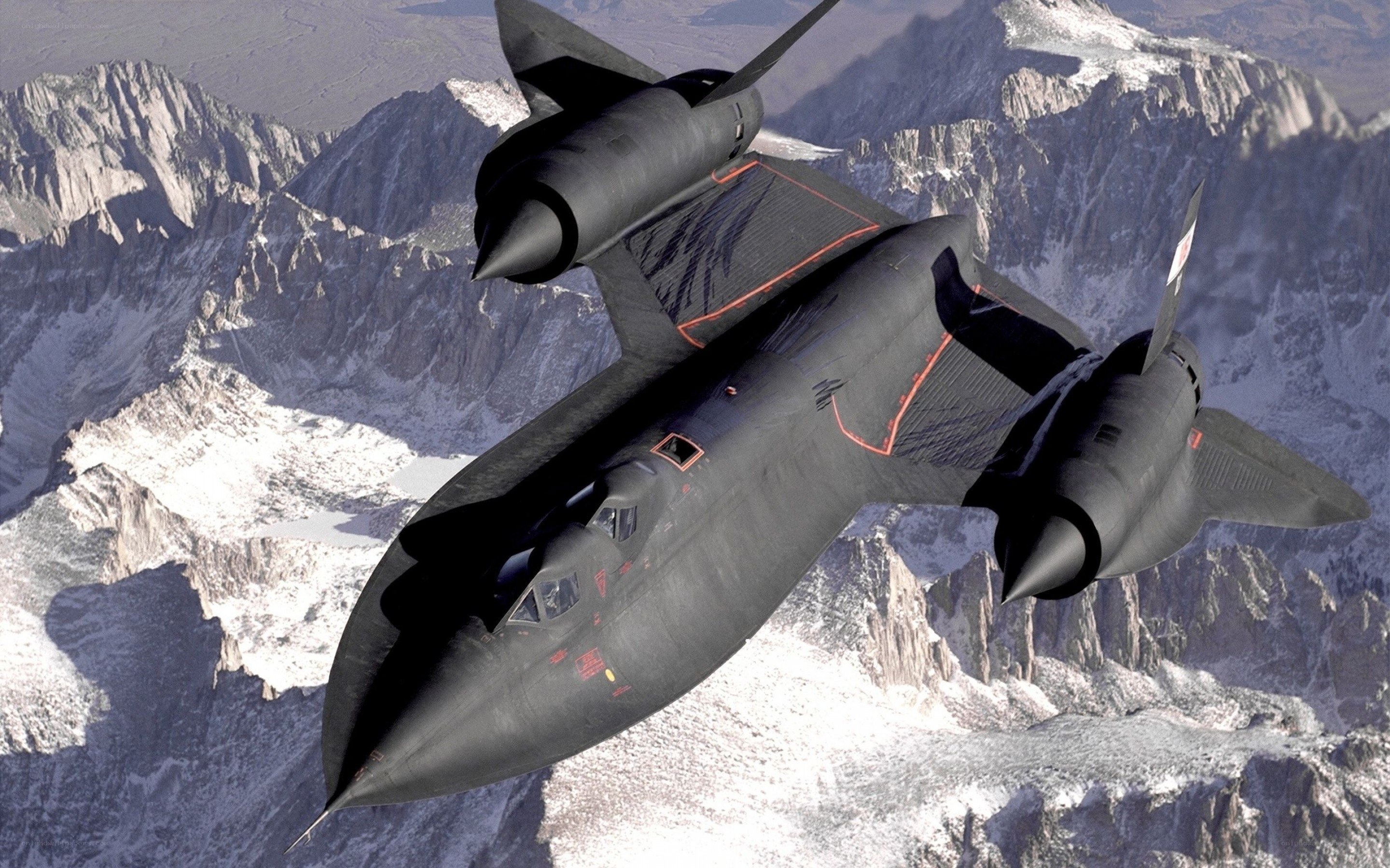 Black jet flying over mountains