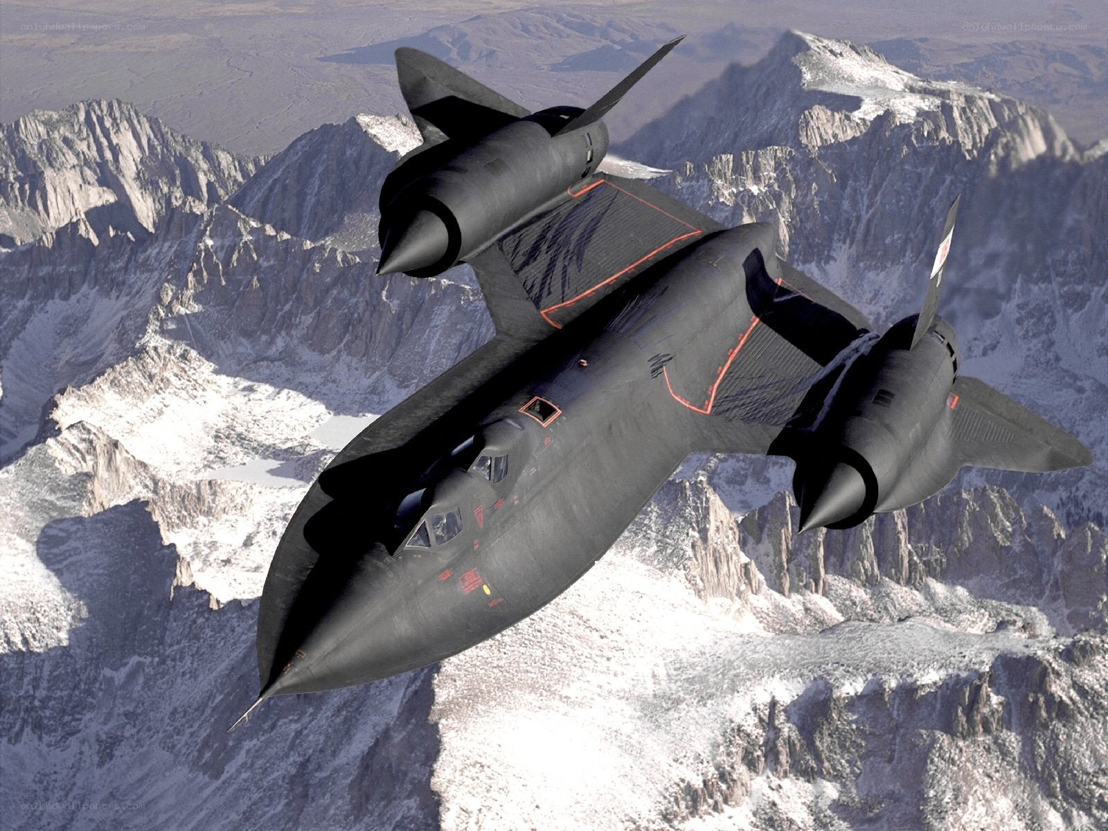 Black jet flying over mountains