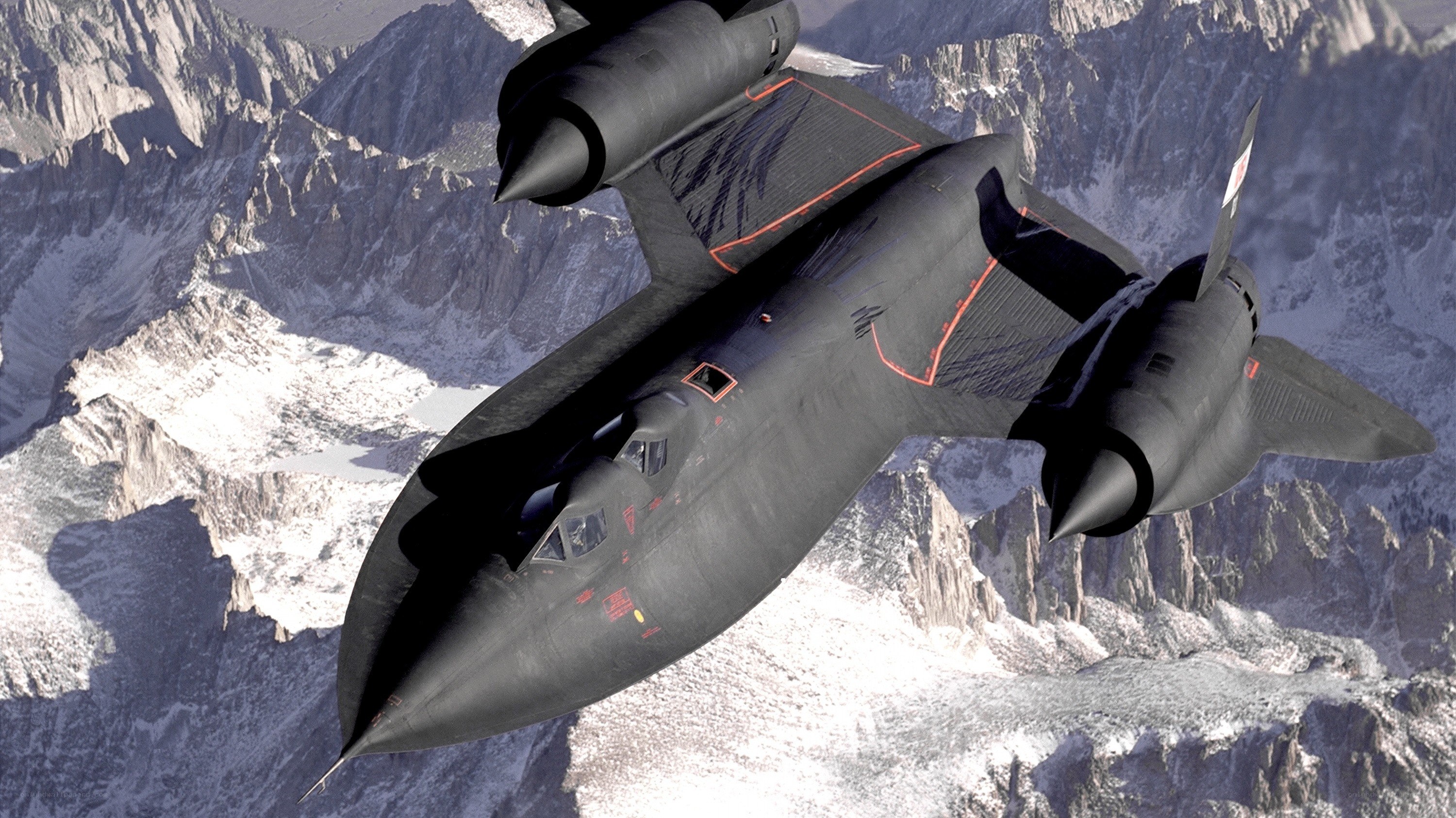 Black jet flying over mountains