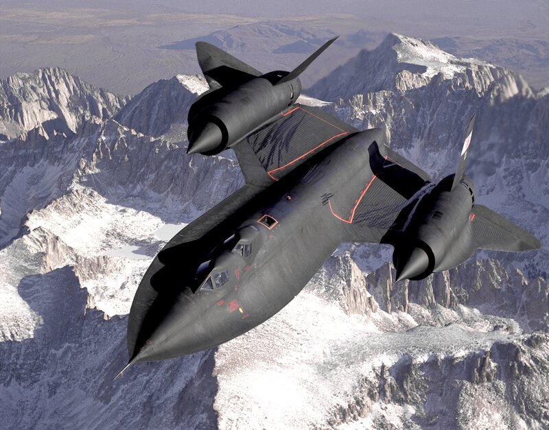 Black jet flying over mountains