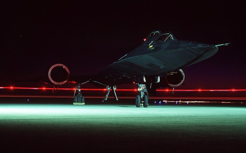 Black jet on tarmac at night