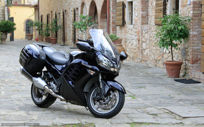 Black Kawasaki motorcycle on cobblestone street