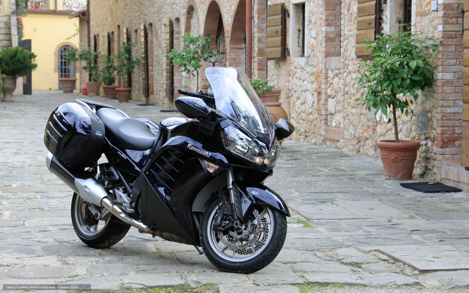 Black Kawasaki motorcycle on cobblestone street