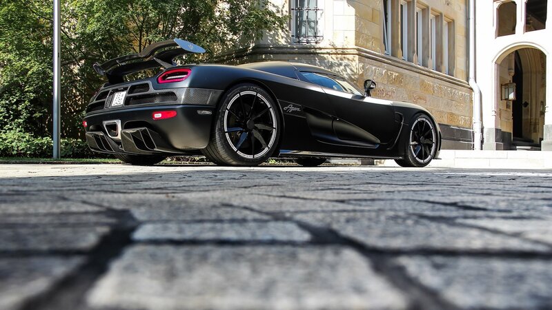 Black Koenigsegg Agera parked on cobblestones