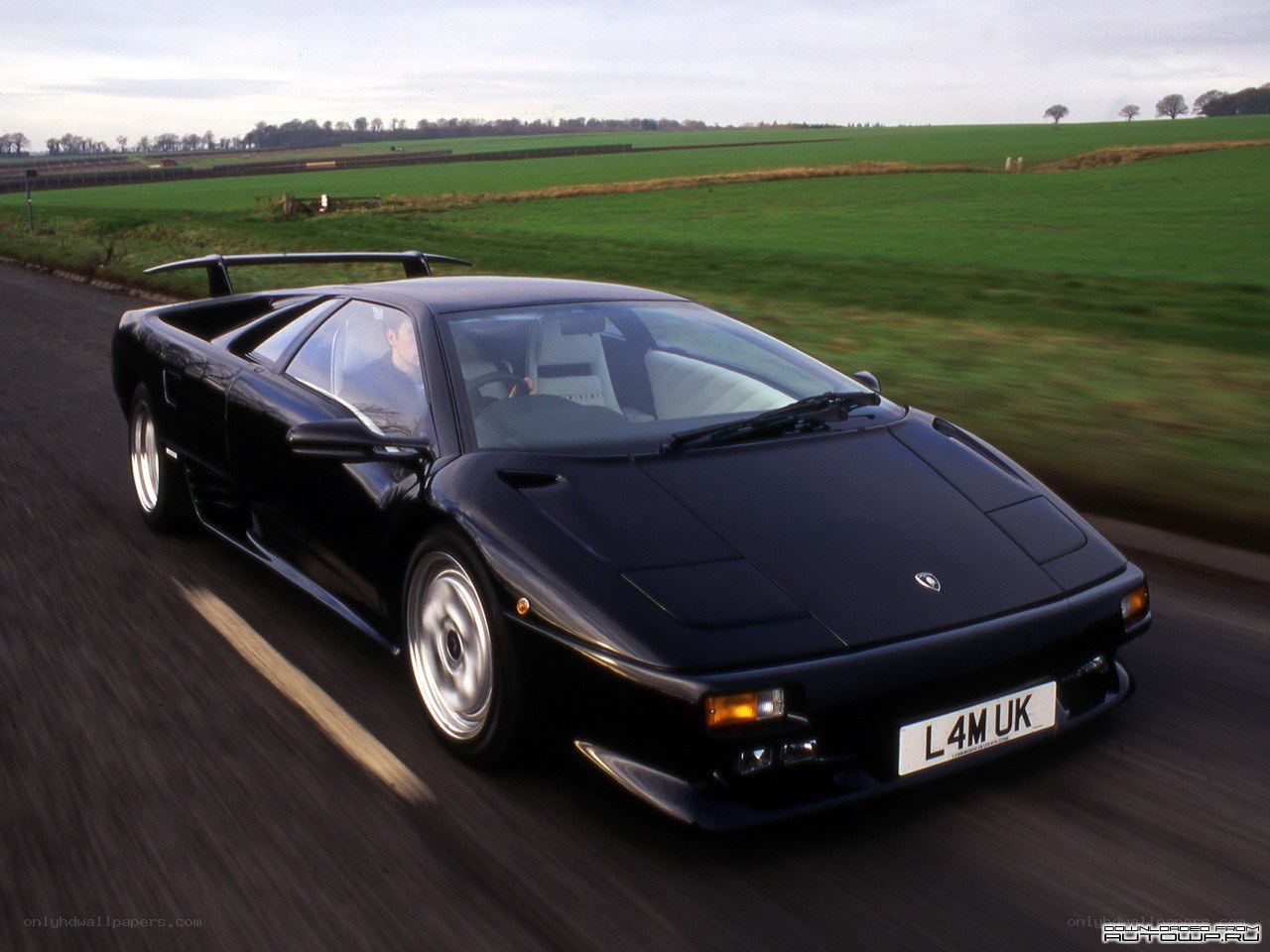 black lamborghini driving on road