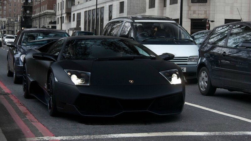black lamborghini in city traffic
