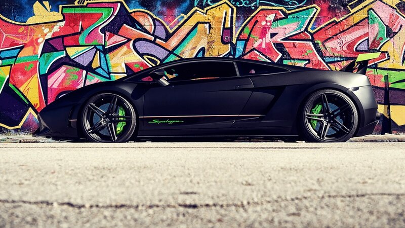 Black Lamborghini in front of graffiti