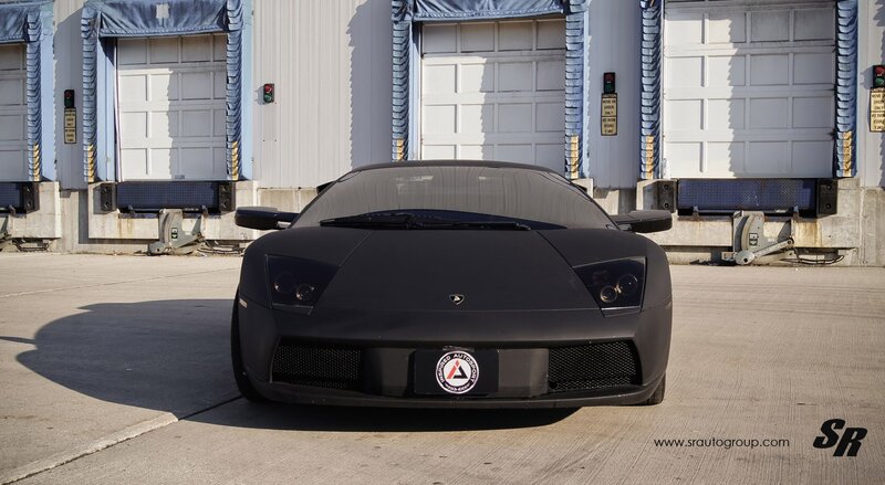 Black Lamborghini in front of warehouse