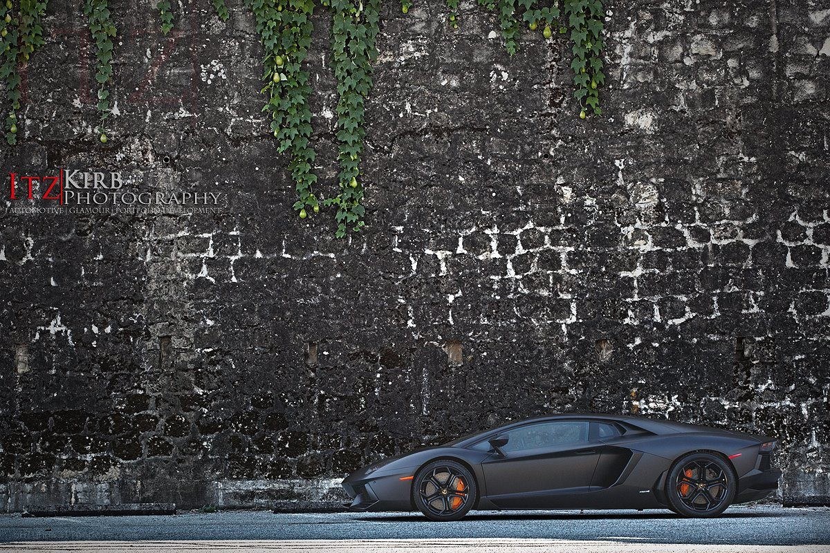 Black Lamborghini on stone wall