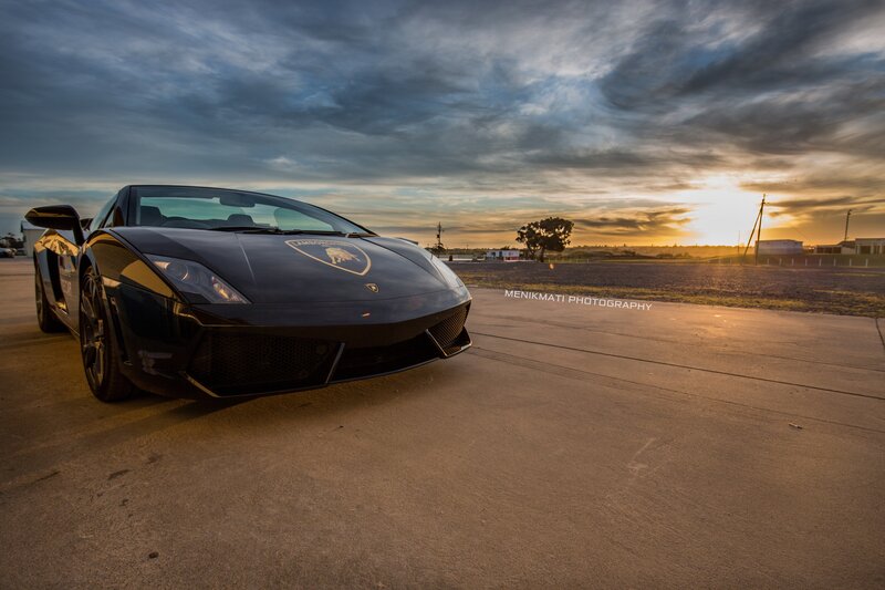 Black Lamborghini Sports Car — Dramatic, Sunset, Photograph, Sky