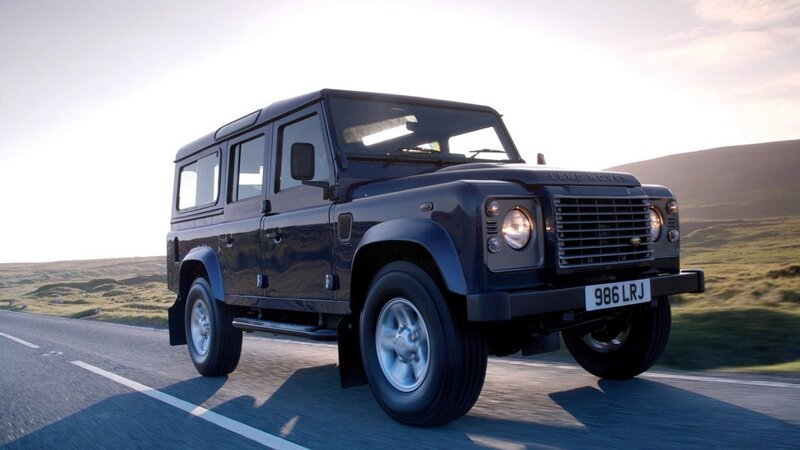 black land rover driving on road