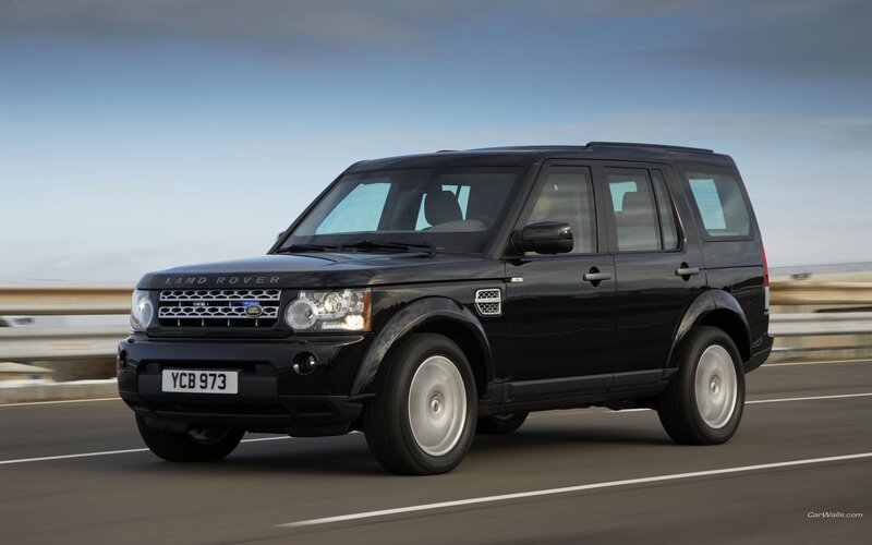 black land rover driving on road