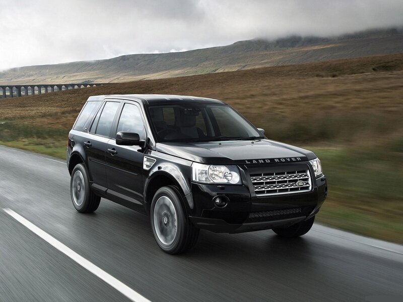Black Land Rover driving on road