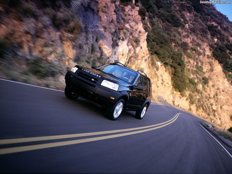 Black Land Rover on winding road