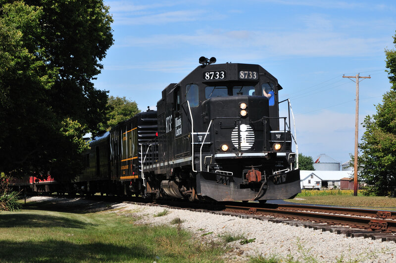 Black locomotive on rural tracks