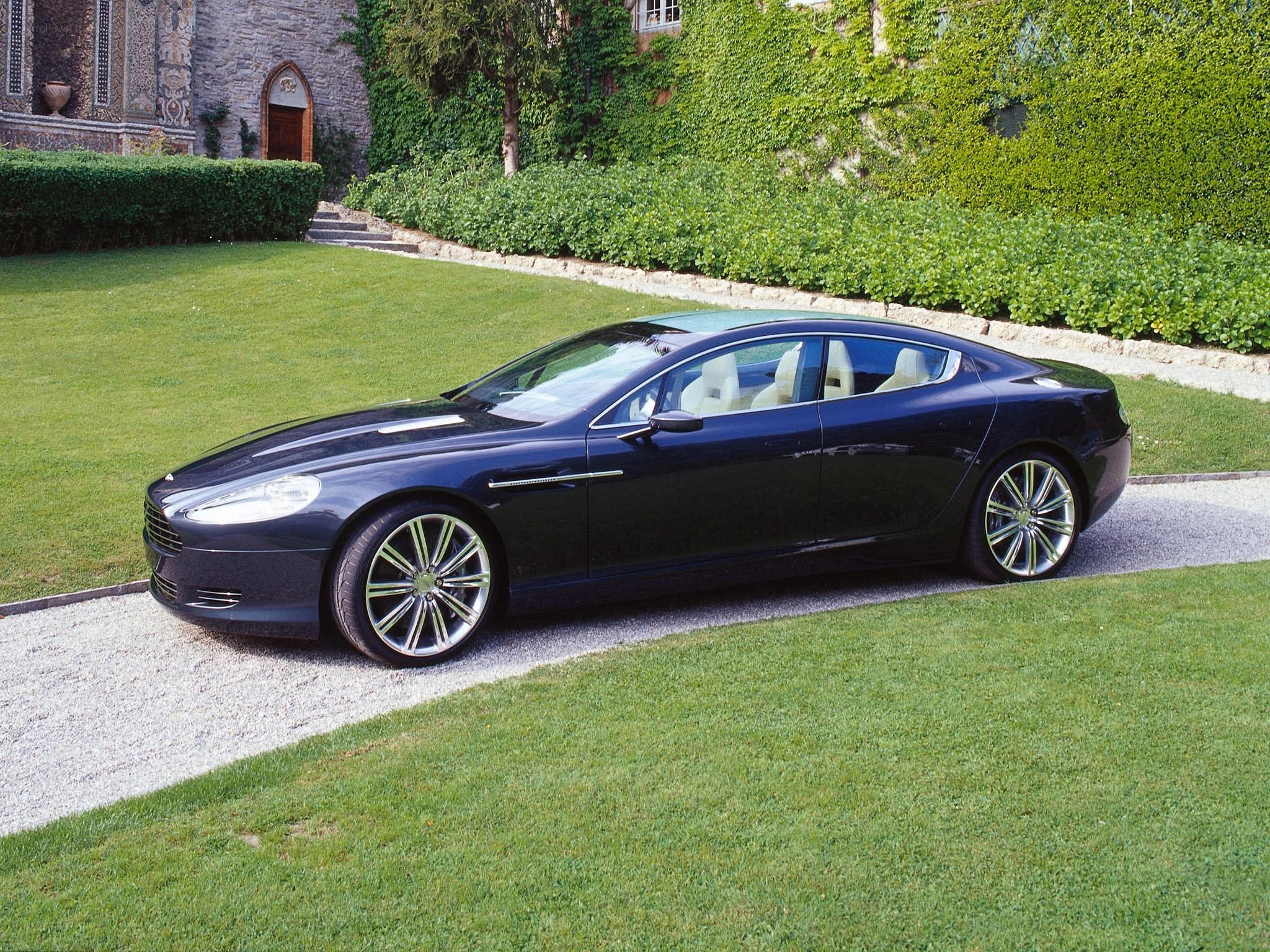 Black luxury sedan on gravel path