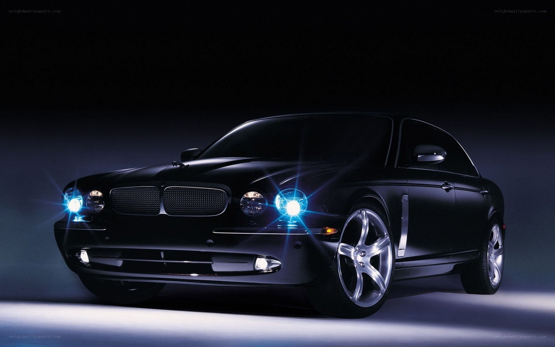 Black luxury sedan with blue headlights