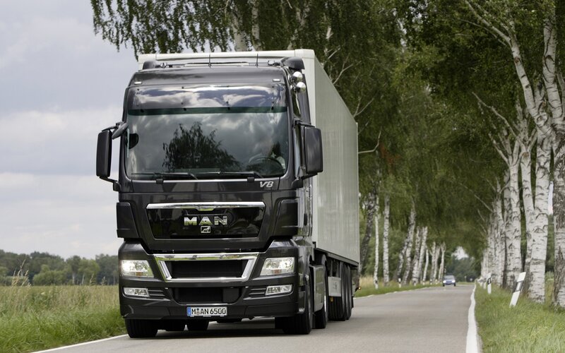 black MAN truck on country road