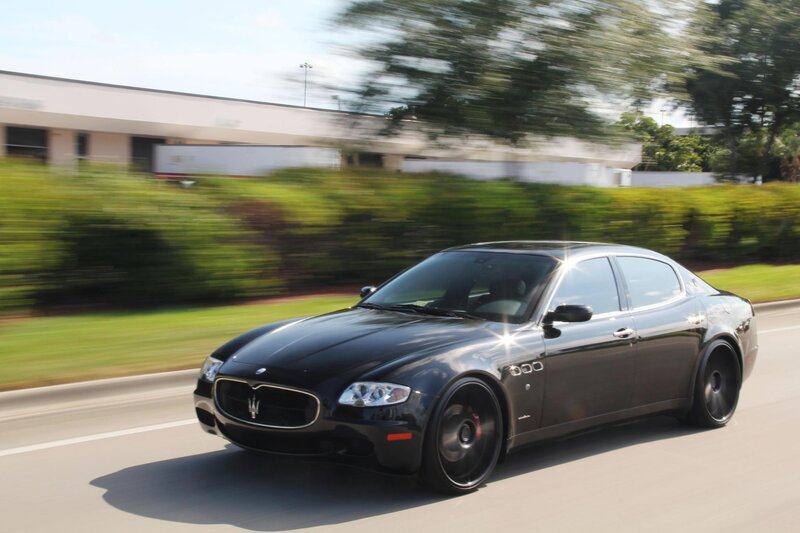 black maserati driving on road