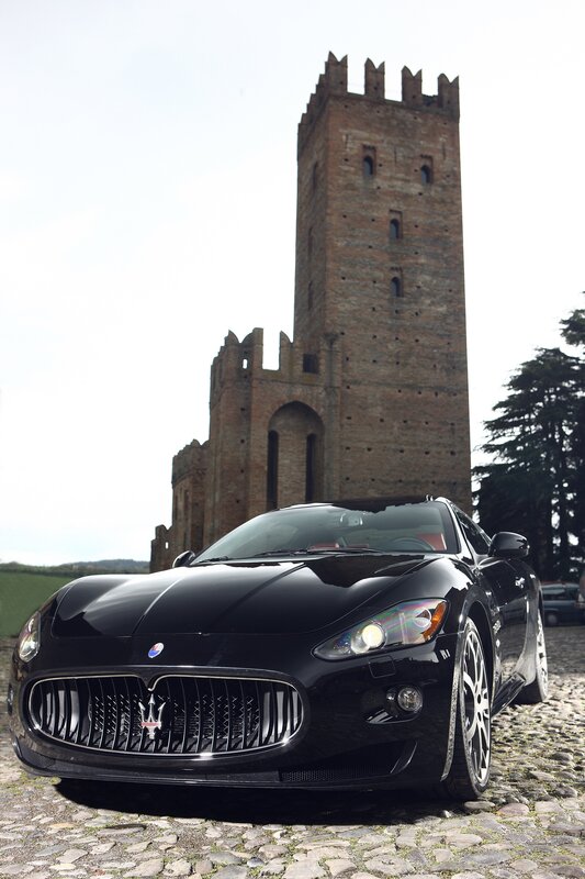 Black Maserati in front of a tower