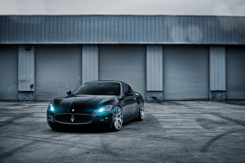 Black Maserati in front of garage