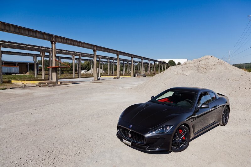 Black Maserati in industrial yard
