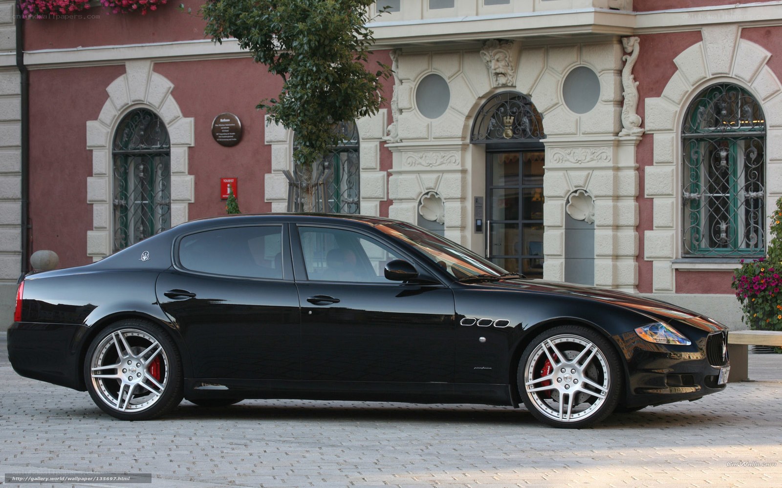 Black Maserati parked on cobblestones