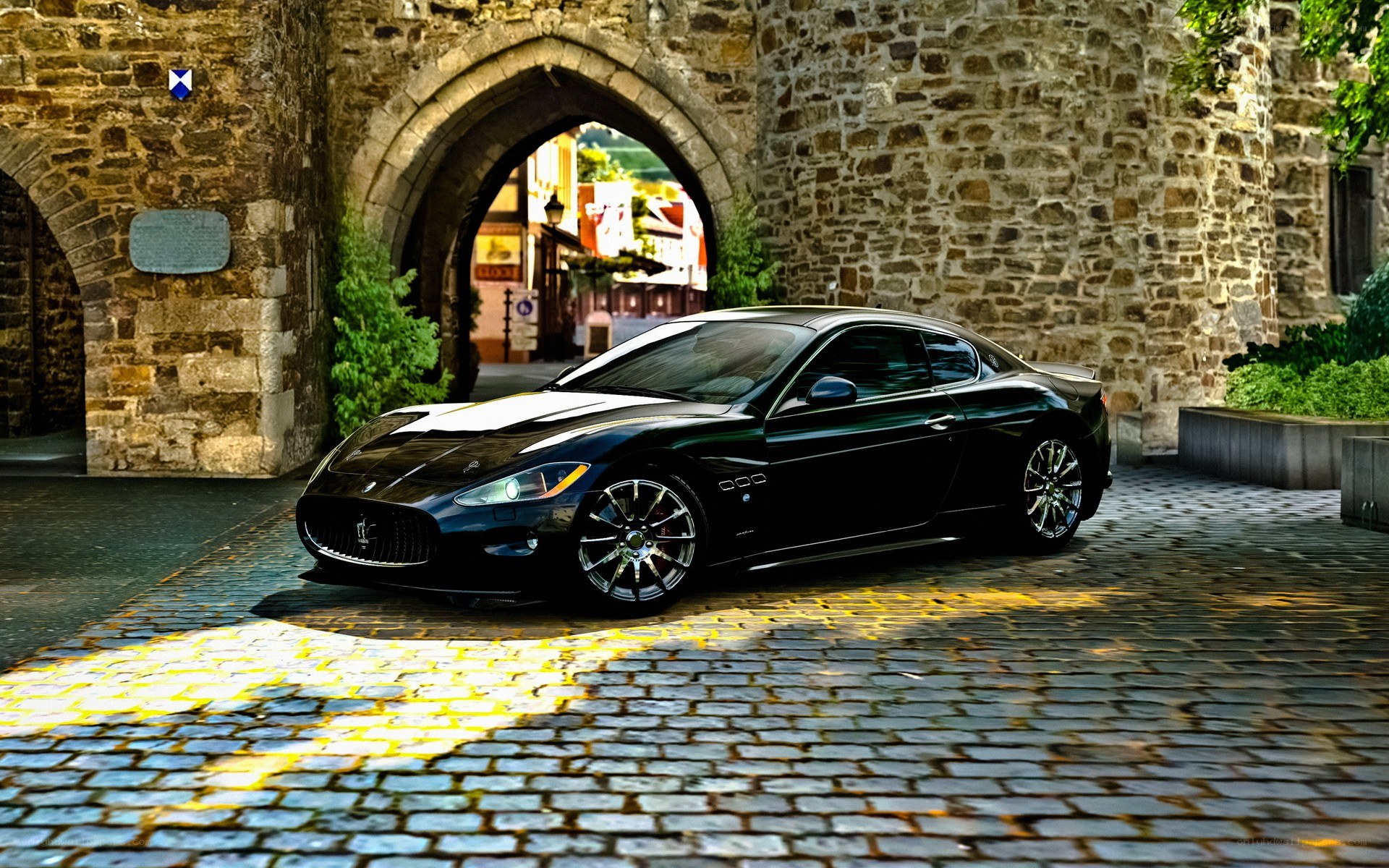 Black Maserati under stone arch