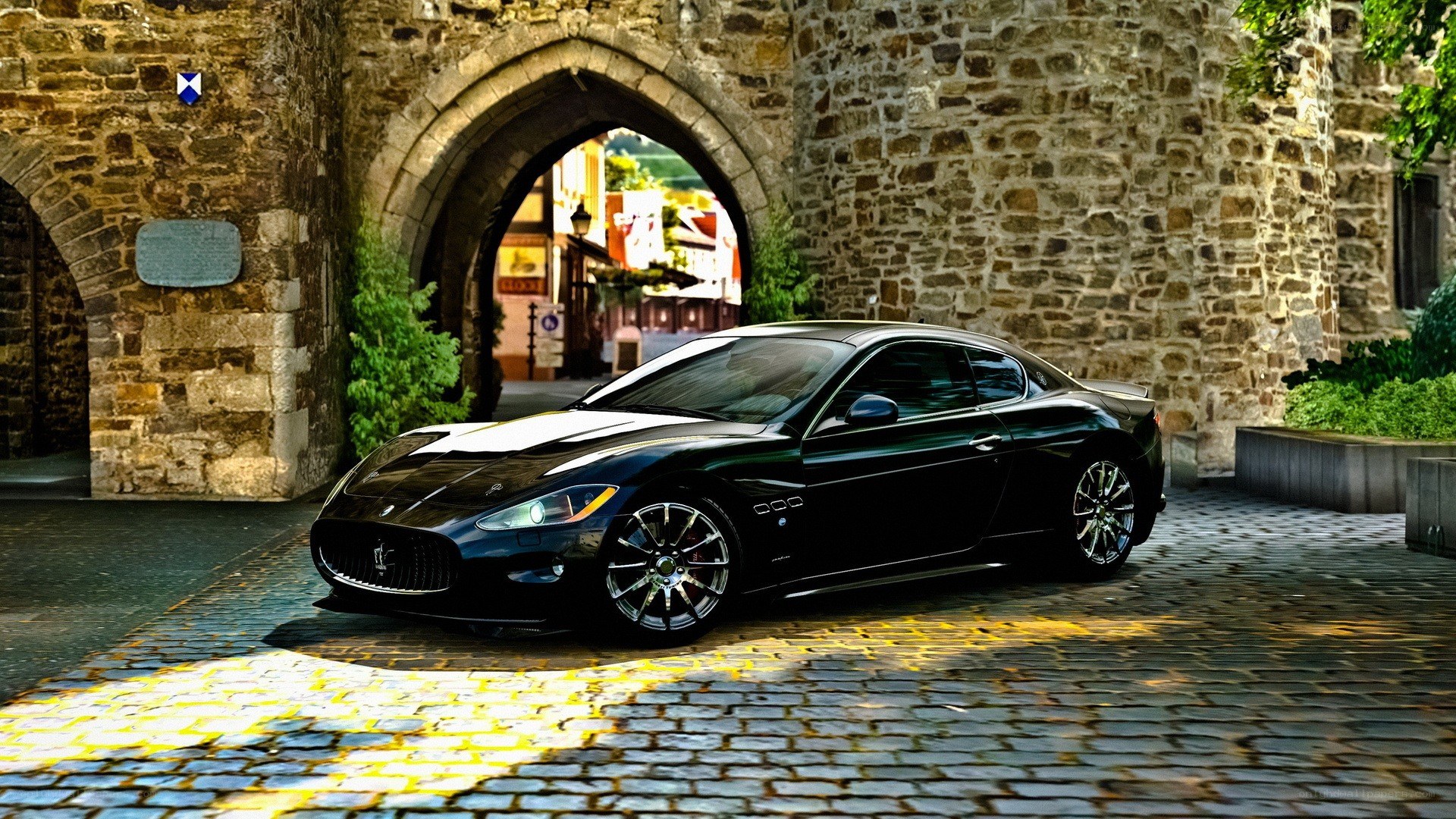 Black Maserati under stone arch