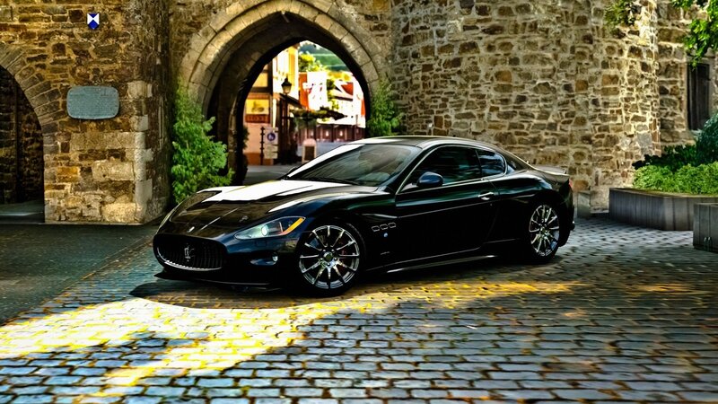 Black Maserati under stone arch