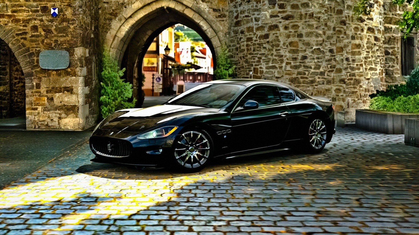Black Maserati under stone arch
