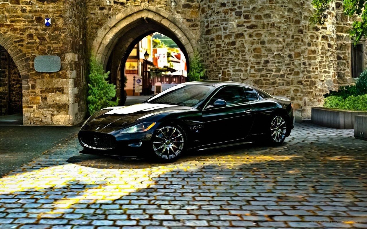 Black Maserati under stone arch