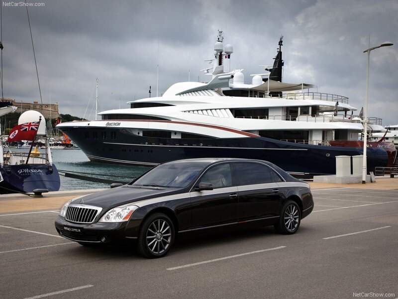 Black Maybach parked near yacht