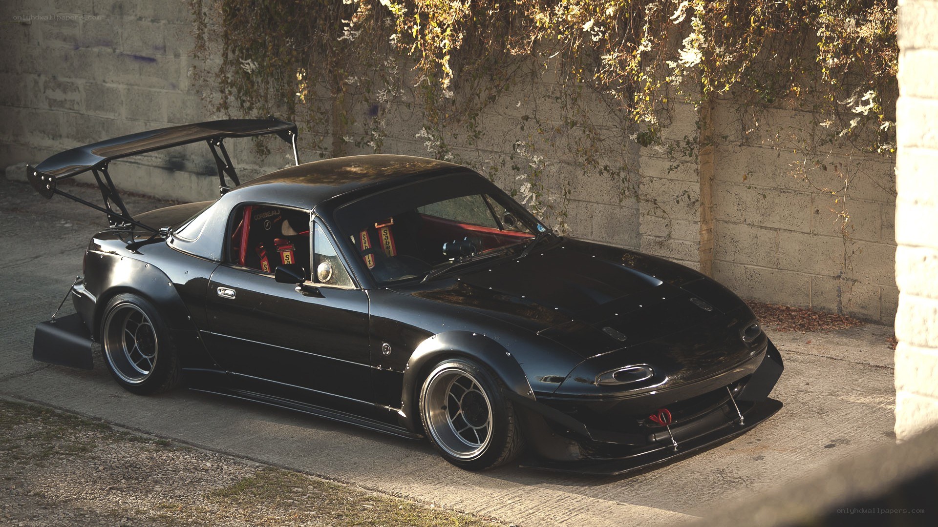black mazda miata with rear wing