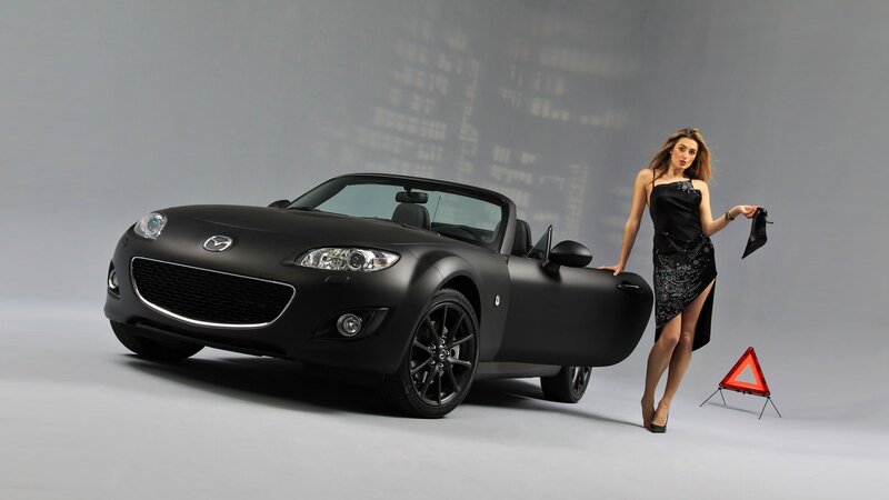 Black Mazda Miata with woman
