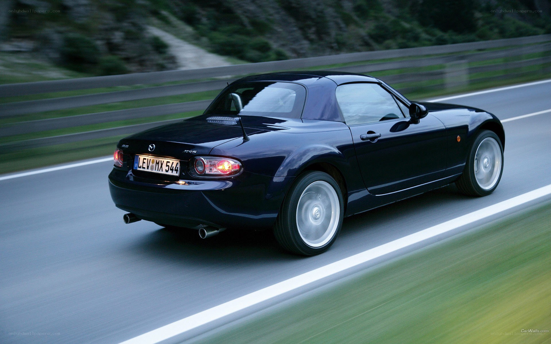 black mazda mx-5 driving on road