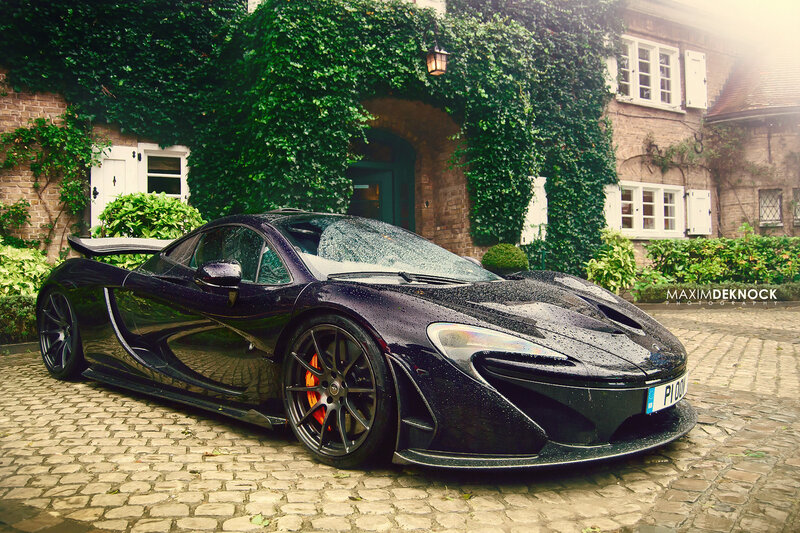 Black McLaren P1 in a cobblestone courtyard