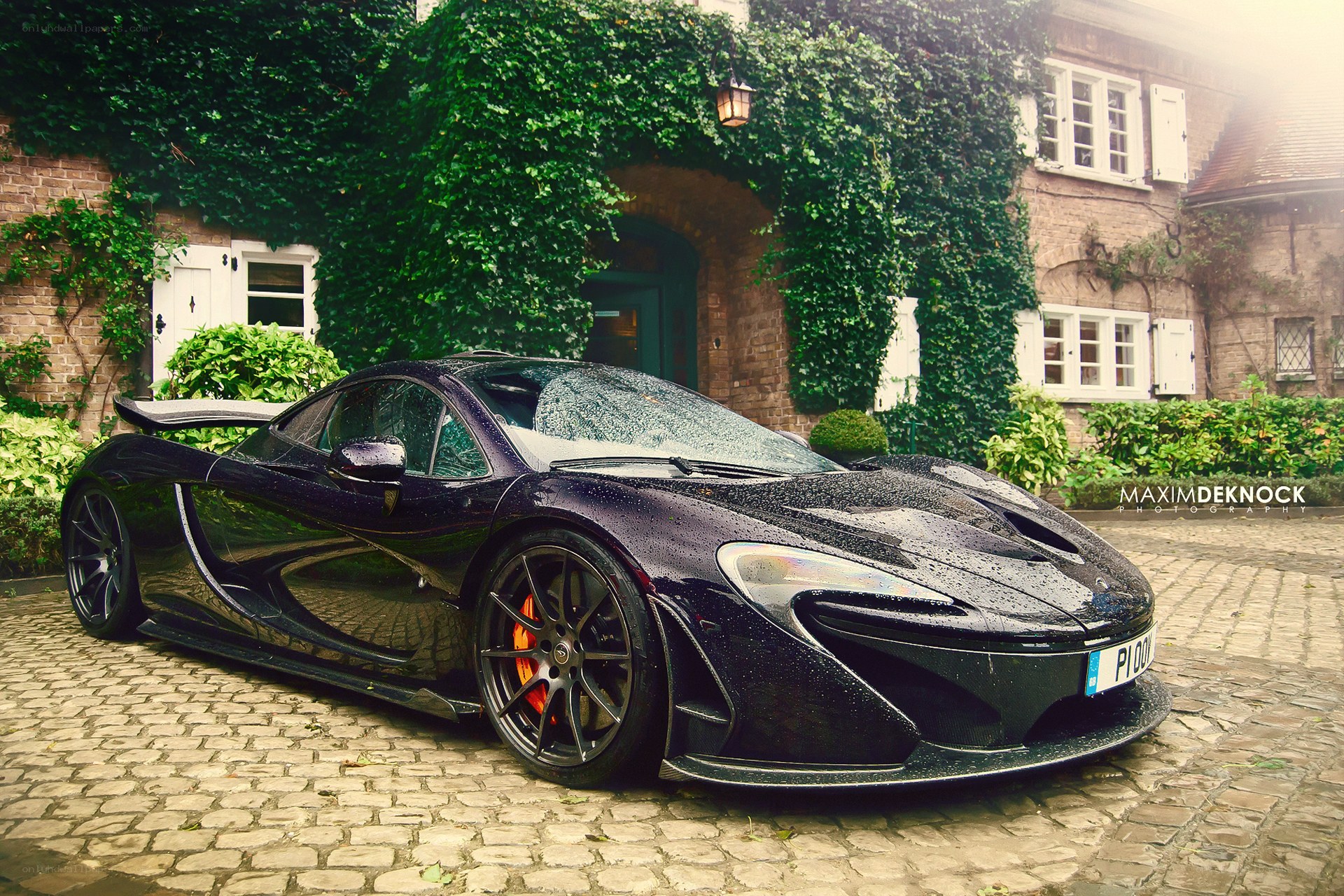 Black McLaren P1 in a cobblestone courtyard
