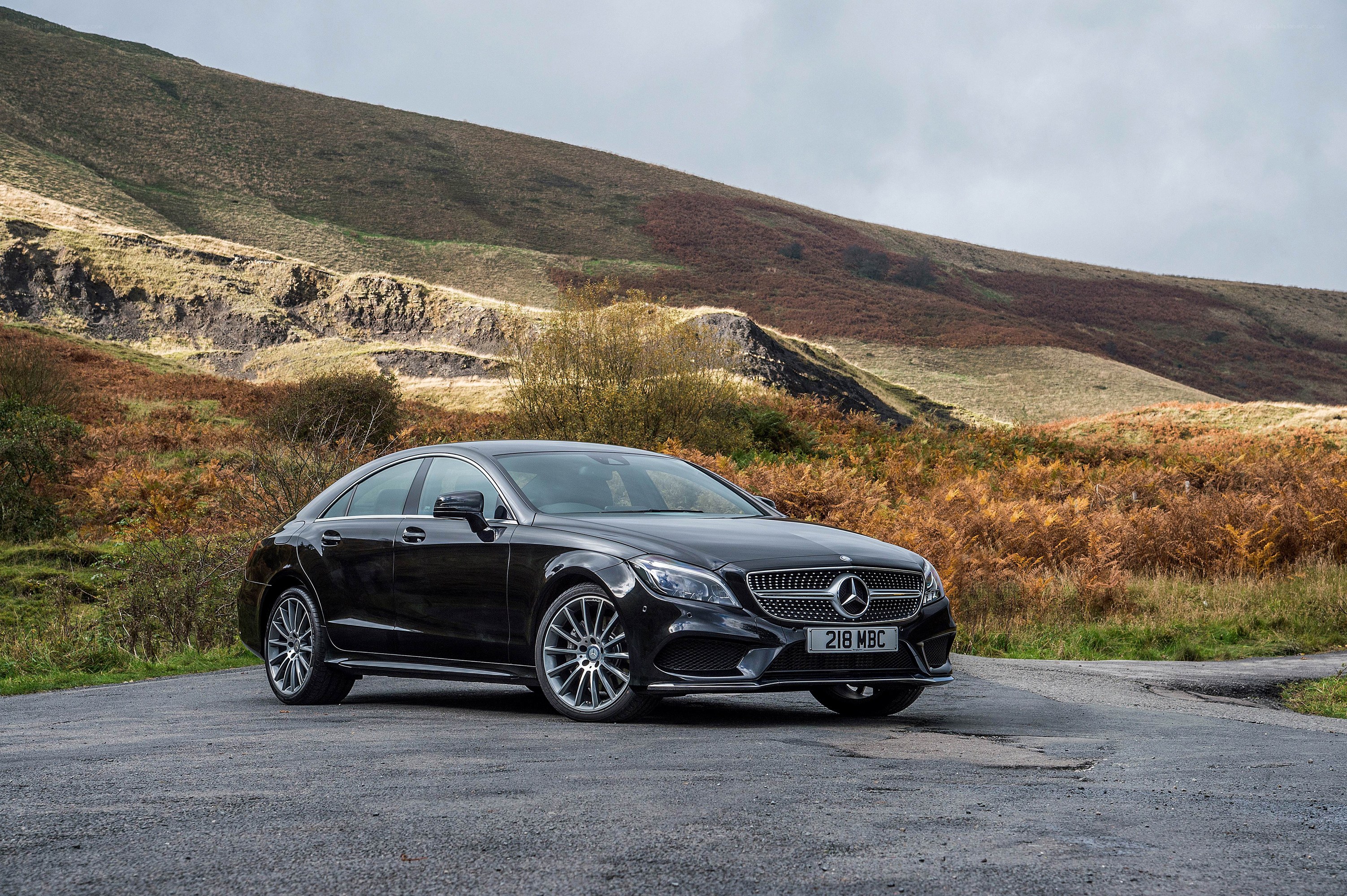 Black Mercedes-Benz CLS on a country road