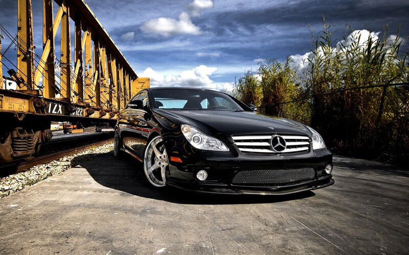 Black Mercedes-Benz CLS parked near train
