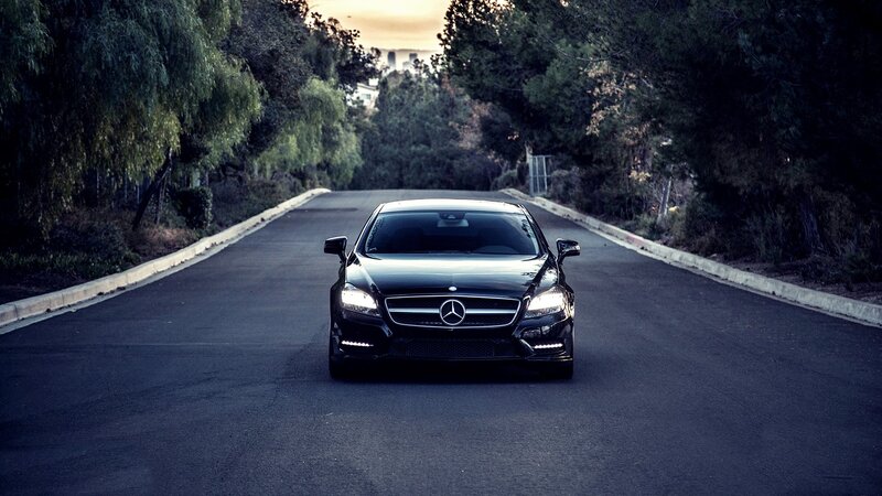 Black Mercedes-Benz on a tree-lined road