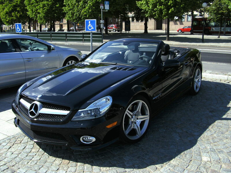 Black Mercedes-Benz SLK parked on cobblestones