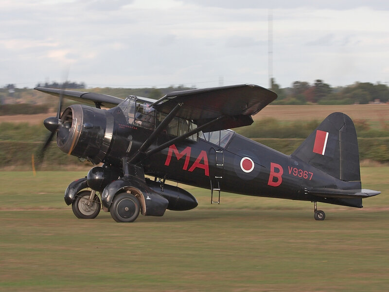 Black military aircraft on grass field